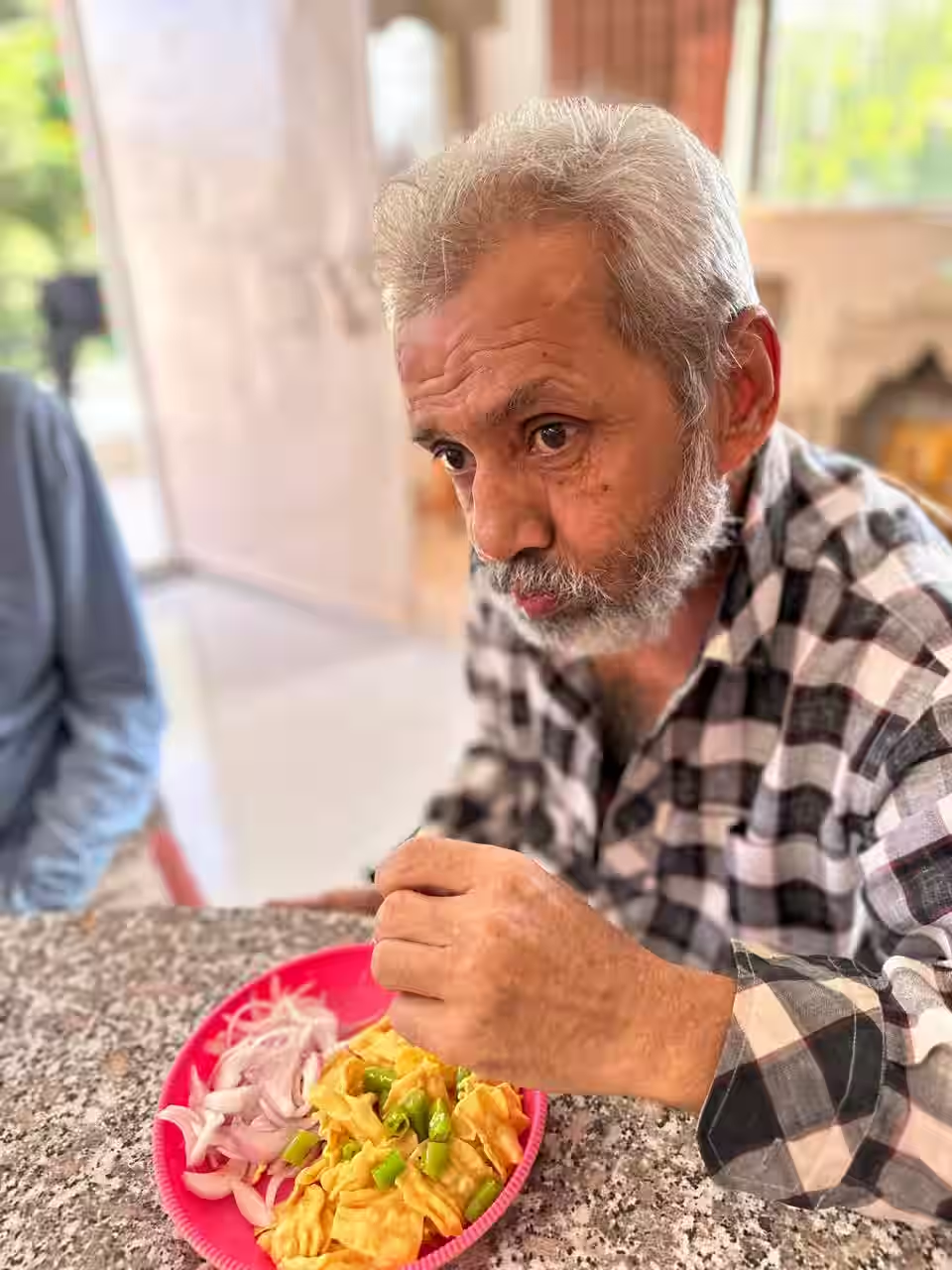 An elderly man eating a freshly prepared meal